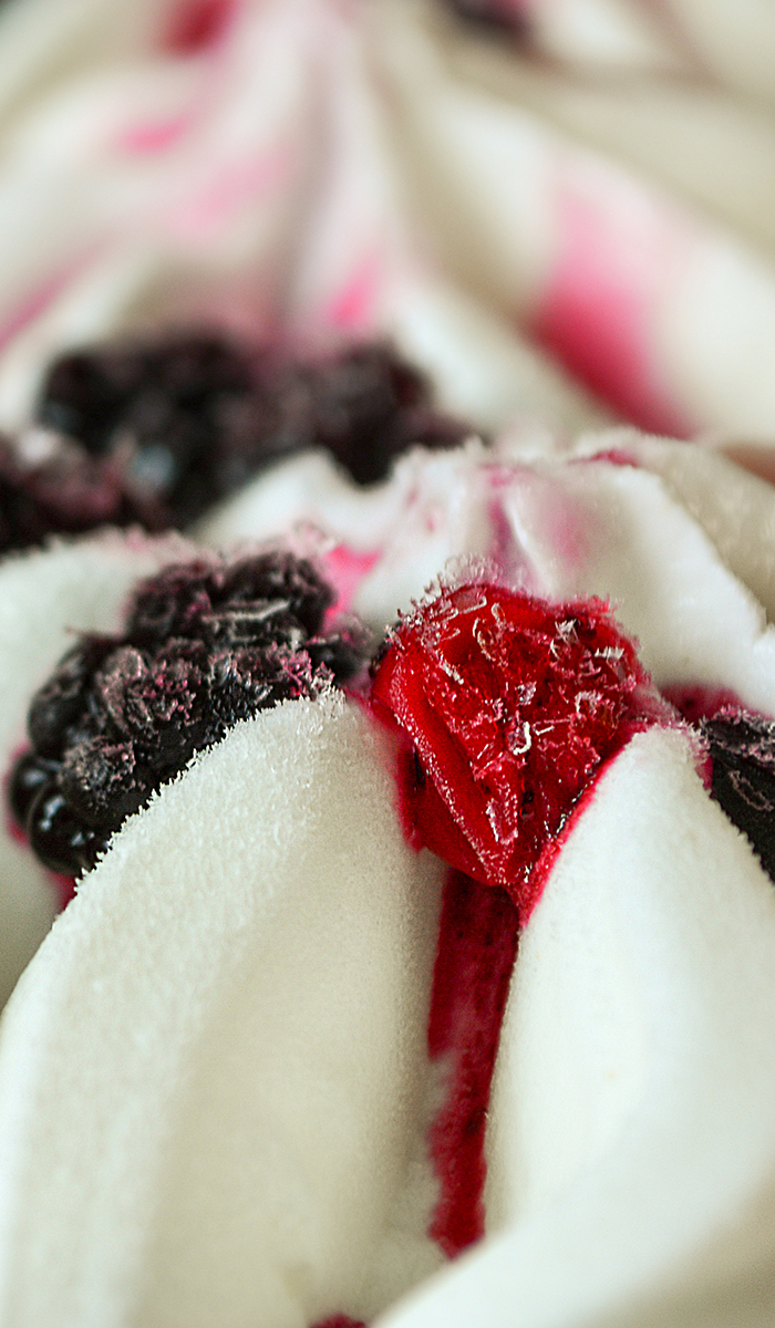 Close up of ice cream with forest frozen berries. Summer food dessert top